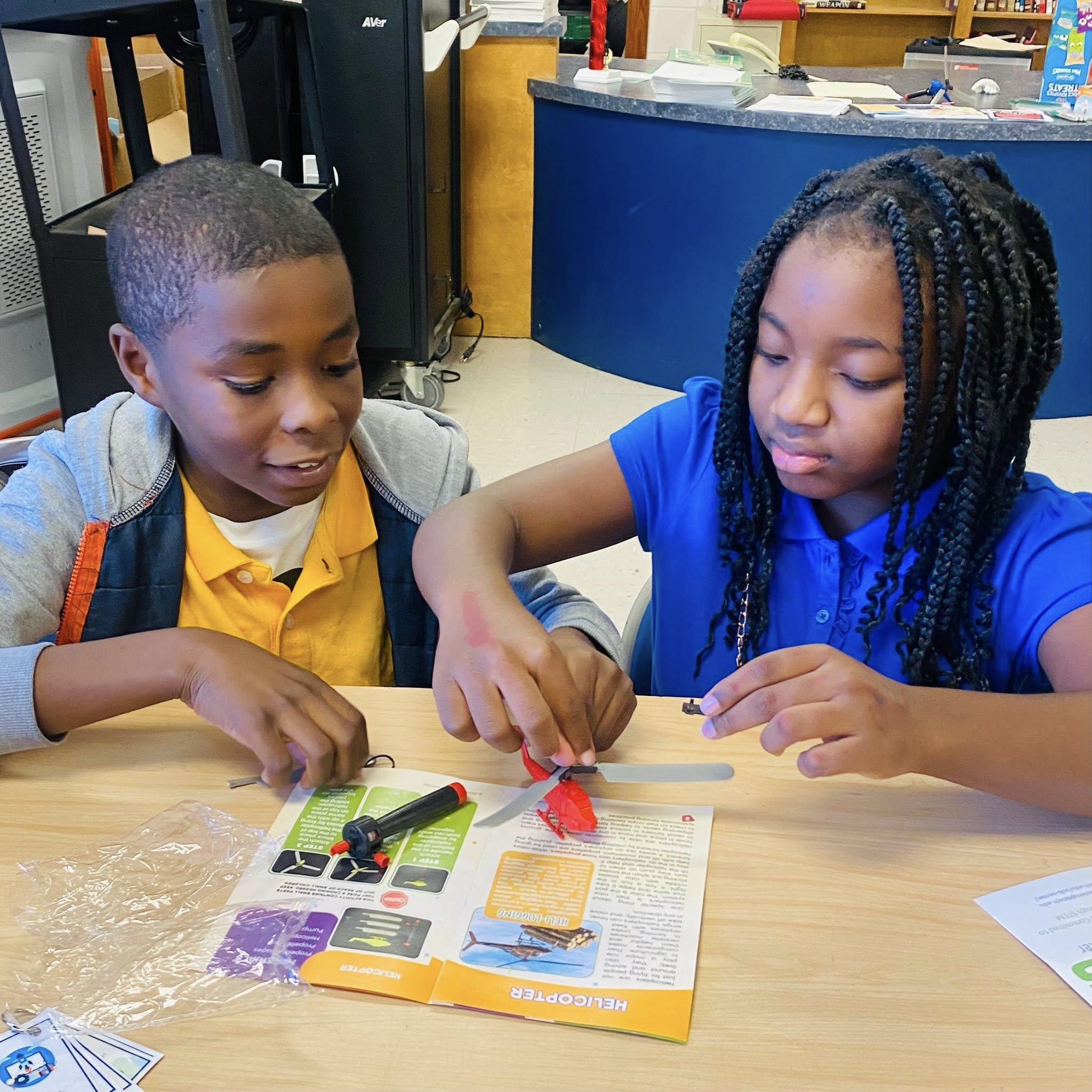 A boy and a girl working on something.